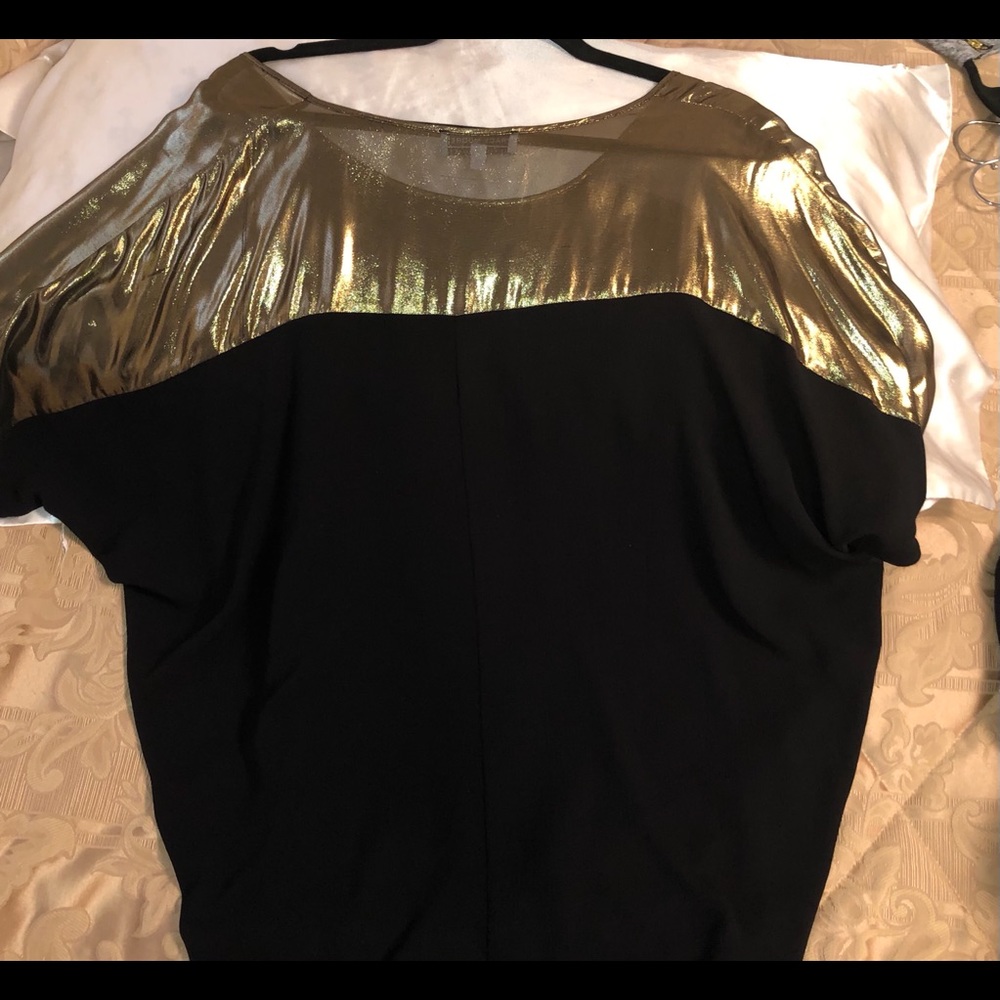 Black blouse with gold shoulder detail.